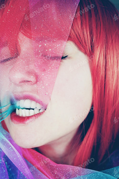 Preview: Artistic portrait of a young redhead woman covering by a glitter chiffon