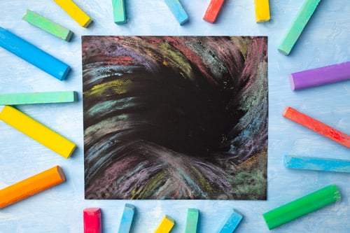 Preview: Colorful chalks on blue background with copy space for text