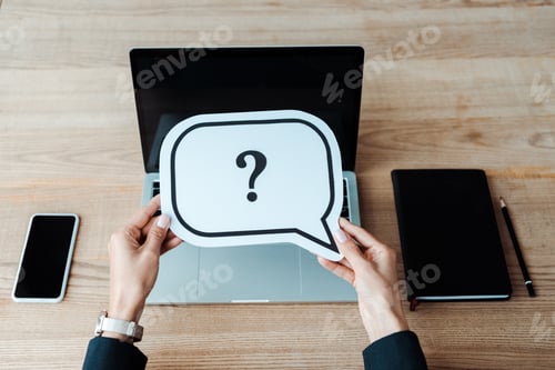 Preview: cropped view of woman holding speech bubble with question mark near laptop with blank screen