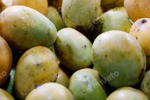 Preview: Closeup shot of a pile of ripe mangos at a market