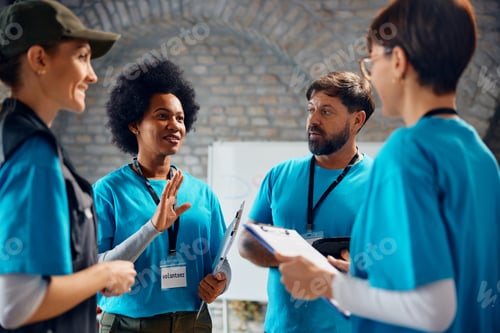 Preview: Multiracial group of volunteers talking while working at community center.