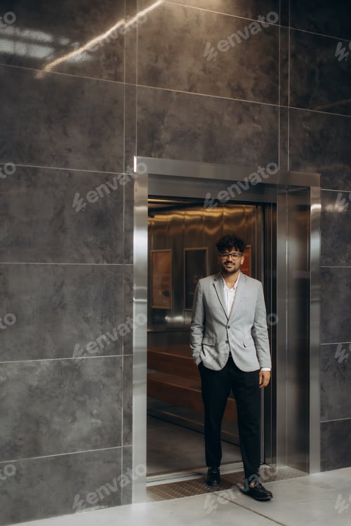 Preview: Gentleman Standing by an Elevator in a Modern Office Building Lobby
