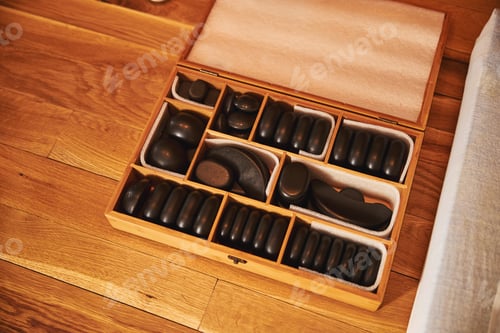 Preview: Box with black massage stones lying on the floor