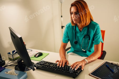 Preview: Female doctor typing on computer at desk with medical tools.