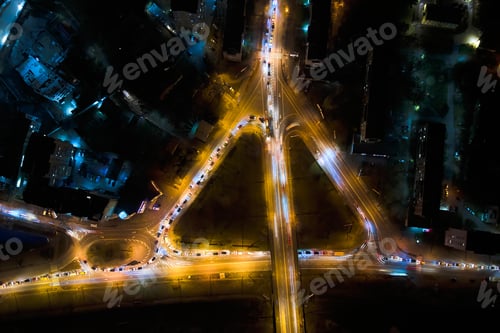 Preview: Aerial view of road intersection with fast moving heavy traffic at night.