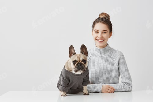Preview: Portrait of smiling brunette woman with hair tied in topknot working at home office. Female