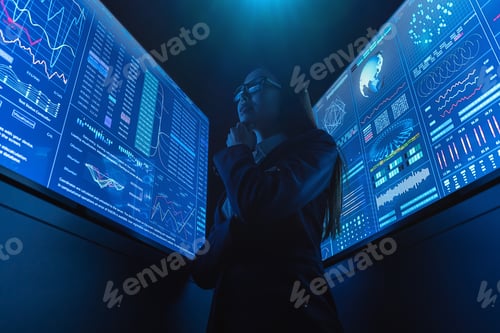 Preview: The businesswoman standing near the blue monitor.
