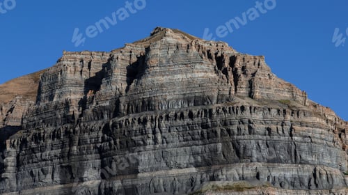 Preview: Steep rocky cliffs rising under clear skies in Svalbard during summer daylight