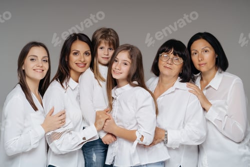 Preview: Women Generations of one family smiling indoors on gray background hugging