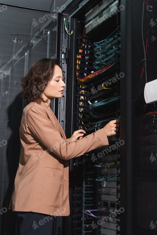 Preview: engineer checking wires of server while working in data center
