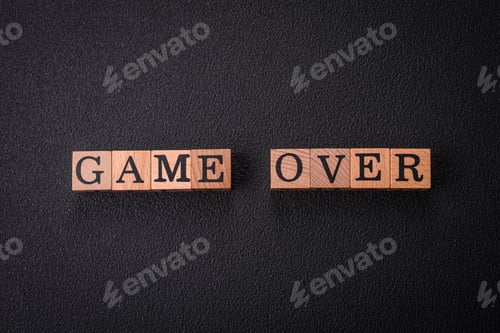 Preview: The inscription game over on wooden cubes on a dark concrete background