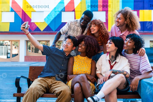 Preview: Multiethnic group of young friends meeting and having fun outdoors