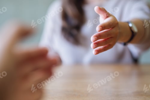 Preview: Closeup image of a young couple reaching and holding hands