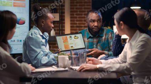 Preview: Business meeting, analytics specialist showing data on laptop screen