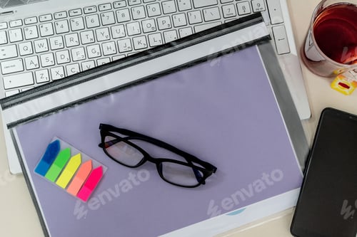 Preview: Top view of a business composition with a laptop, glasses, pen, notebook, tea on a work desk