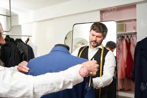 Preview: Professional fashion designers fitting item of clothing on mannequin