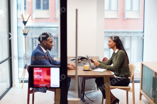 Preview: Businesswoman Interviewing Male Job Candidate In Meeting Room