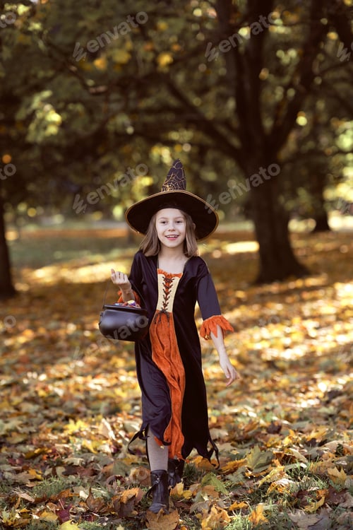 Preview: Vertical image of girl in witch outfit and walking in the woods