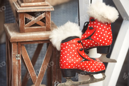 Preview: Red polka dot fur trimmed vintage ice skates hang on the house veranda