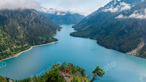 Preview: Breathtaking view of Plansee lake in Austria with hikers admiring the majestic landscape