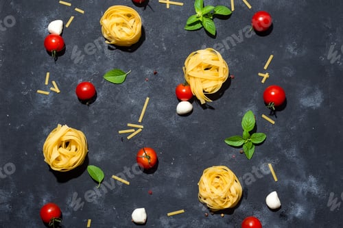 Preview: Pasta pattern. Several types of dry pasta with vegetables and herbs on a dark stone table.