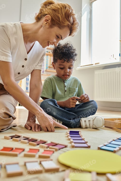 Preview: Montessori school, happy teacher pointing at wooden colorful blocks near african american boy, smart