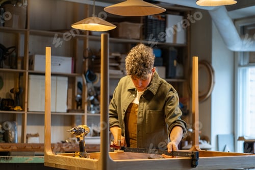 Preview: Carpenter uses clamp to secure wooden table base for smooth installation in workshop. Custom design