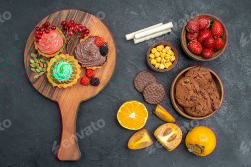 Preview: top view delicious little cakes with biscuits and fruits on dark background sweet pie cake