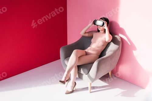 Preview: beautiful young woman in bodysuit and high heeled shoes using vr headset on pink