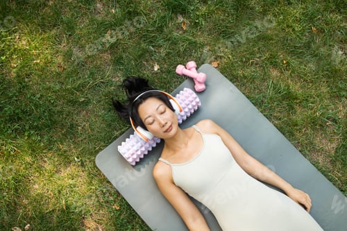 Preview: Young Asian woman in sportswear on fitness mat at public park