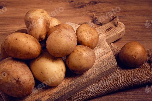 Preview: Raw potatoes, scattered on a chopping board, close-up, no people,