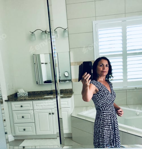 Visualização: Mulher tirando uma selfie no banheiro.