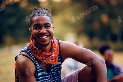 Preview: Happy black festival goer in the park looking at camera.