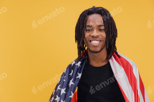 Preview: Young african american man smiling with american flag on yellow background