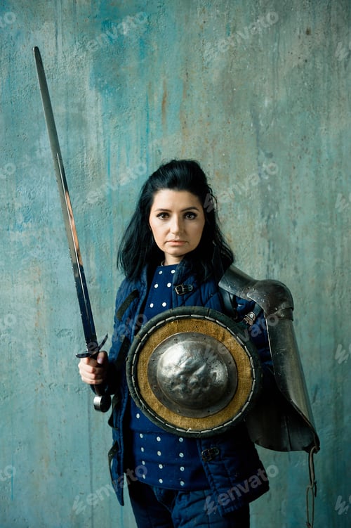Preview: Beautiful brunette woman in ancient iron knightly armor. Medieval female knight in armor.