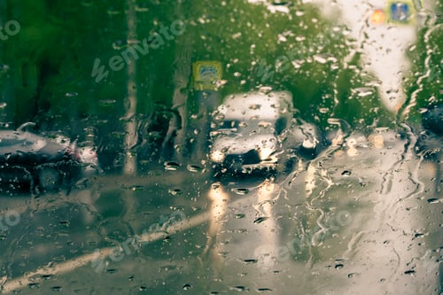 Preview: Car traffic through glass with raindrops. Sunny autumn day. Front view.