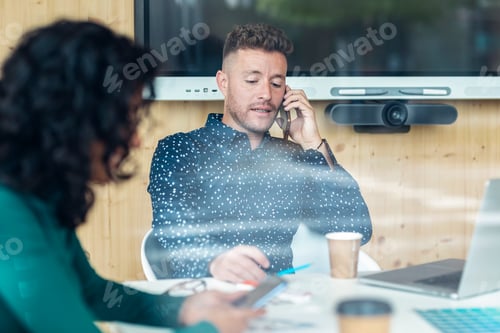 Preview: Successful business team working together with laptop while using smartphone in coworking place.