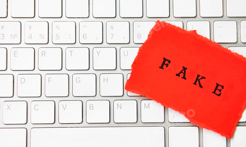 Preview: Words Fake News written under torn paper