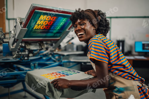 Preview: Happy interracial worker finishing silk screen printing at workshop.