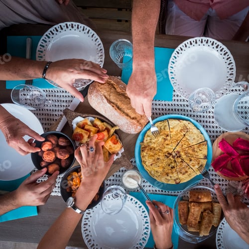Preview: Vertical above view of table ready for dinner or lunch with lot of food and drinks and hands