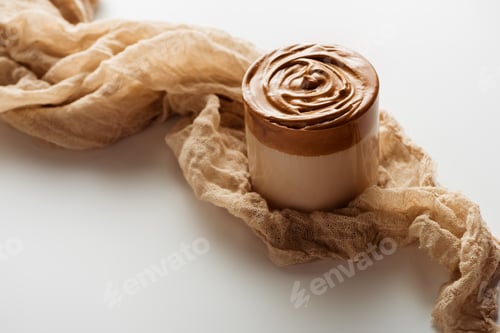 Preview: Delicious Dalgona Coffee in Glass Near Cloth on White Background