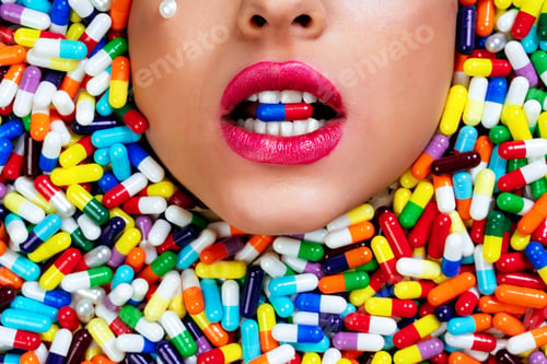 Preview: Artistic image of a beautiful woman sunk inside colored pills and capsules.