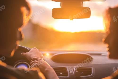 Preview: The man and woman drive a car on the background of the sunset