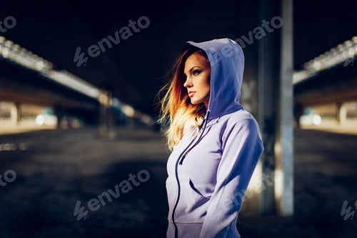 Preview: Portrait of a young beautiful woman in a hoodie in an urban environment