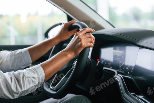 Preview: Close up view. Woman is sitting in a car and driving it