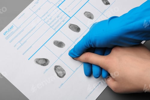 Preview: Investigator taking fingerprints of suspect at table, closeup. Criminal expertise