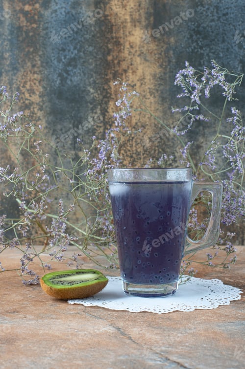 Preview: A cup of delicious drink with slice of kiwi on marble background