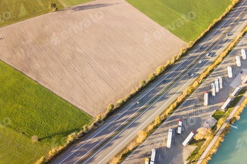 Preview: Top down aerial view of highway interstate road with fast moving traffic and parking lot with parked