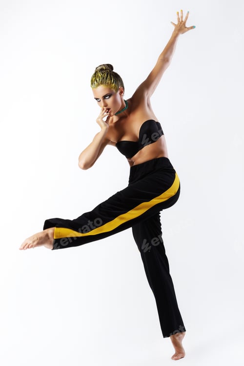 Preview: Stylish woman with yellow hair and trackpants on gray background