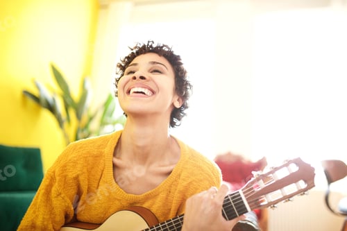 Preview: Close up happy young african american woman laughing with guitar